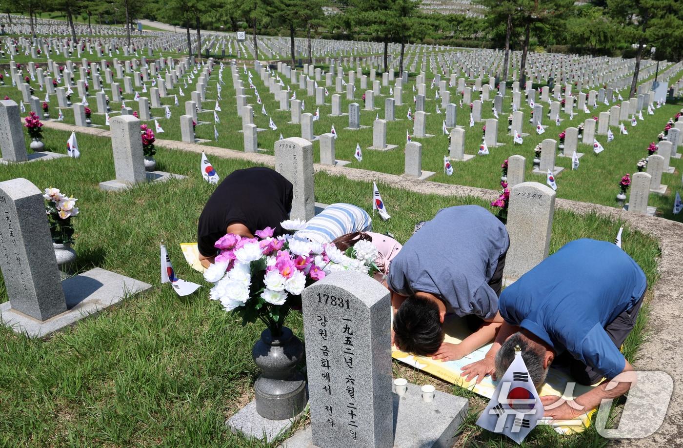 본문 이미지 - 지난해 6·25전쟁 75주년을 맞아 서울 동작구 국립서울현충원 묘역에서 6·25전쟁 전사자 유족들이 참배를 하고 있다. 2025.6.22 ⓒ 뉴스1 김명섭 기자