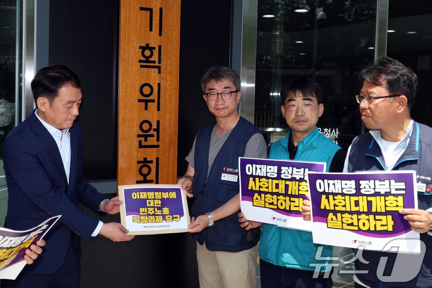 민주노총 조합원들이 23일 오전 서울 종로구 정부서울청사 창성동별관 국정기획위원회 앞에서 노동기본권·사회대개혁 국정과제 수용 촉구 기자회견을 마친 후 이옥남 사회1분과 전문위원에게 요구안을 전달하고 있다. 2025.6.23/뉴스1 ⓒ News1 황기선 기자