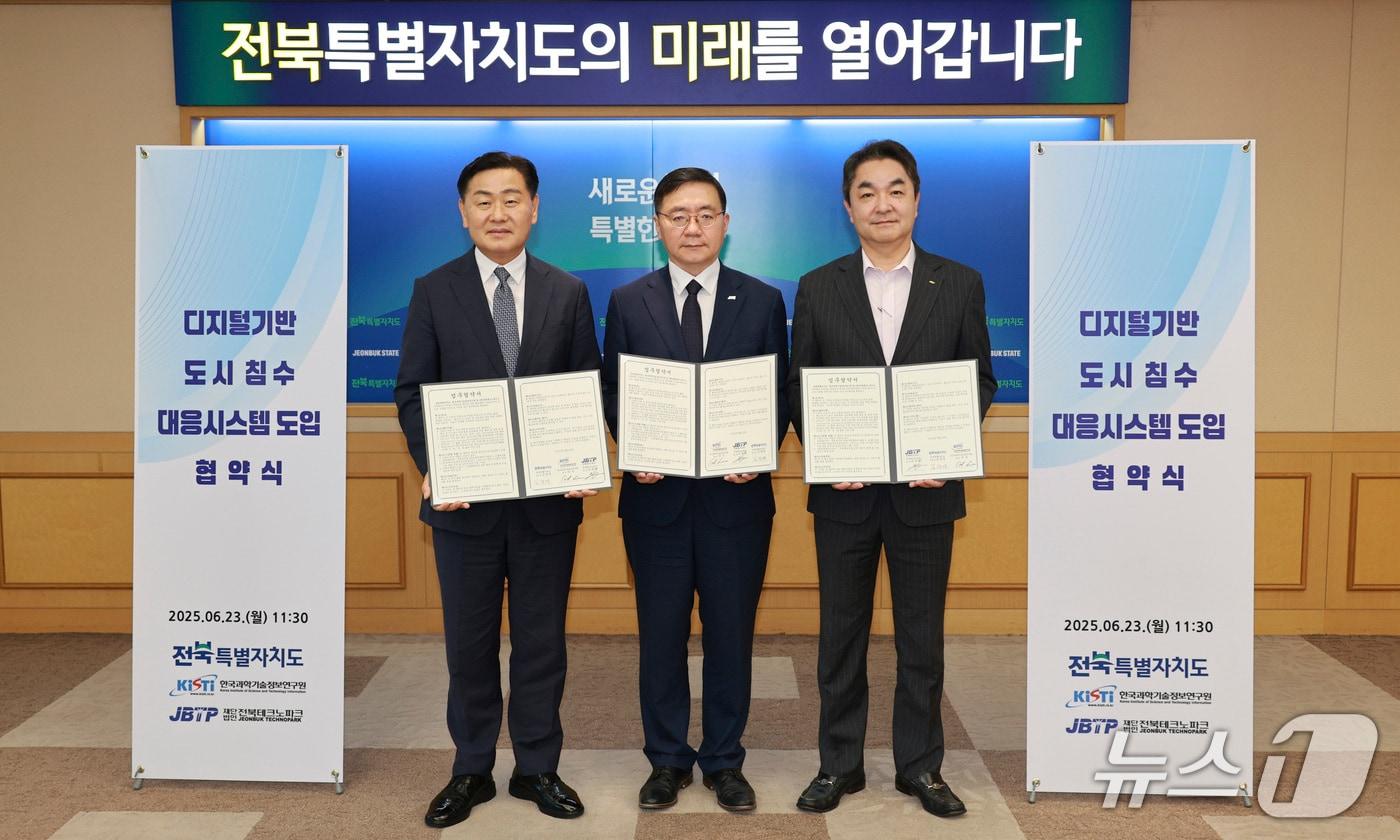 23일 전북도청에서 한국과학기술정보연구원-전북테크노파크-전북도의 '디지털 기반 도시침수 대응시스템 도입 업무협약'이 체결된 가운데 참석자들이 기념 촬영을 하고 있다.(전북도 제공. 재판매 및 DB금지)/뉴스1 