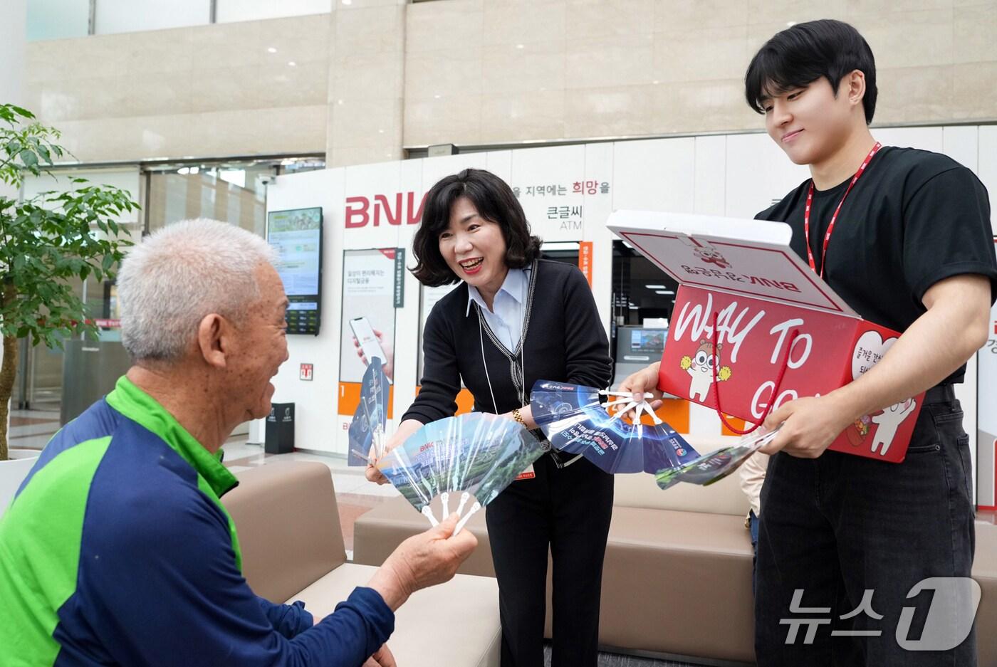 BNK경남은행 직원들이 무더위 쉼터로 운영되고 있는 영업점에서 지역민에게 부채를 나눠주고 있다.(경남은행 제공. 재판매 및 DB금지)