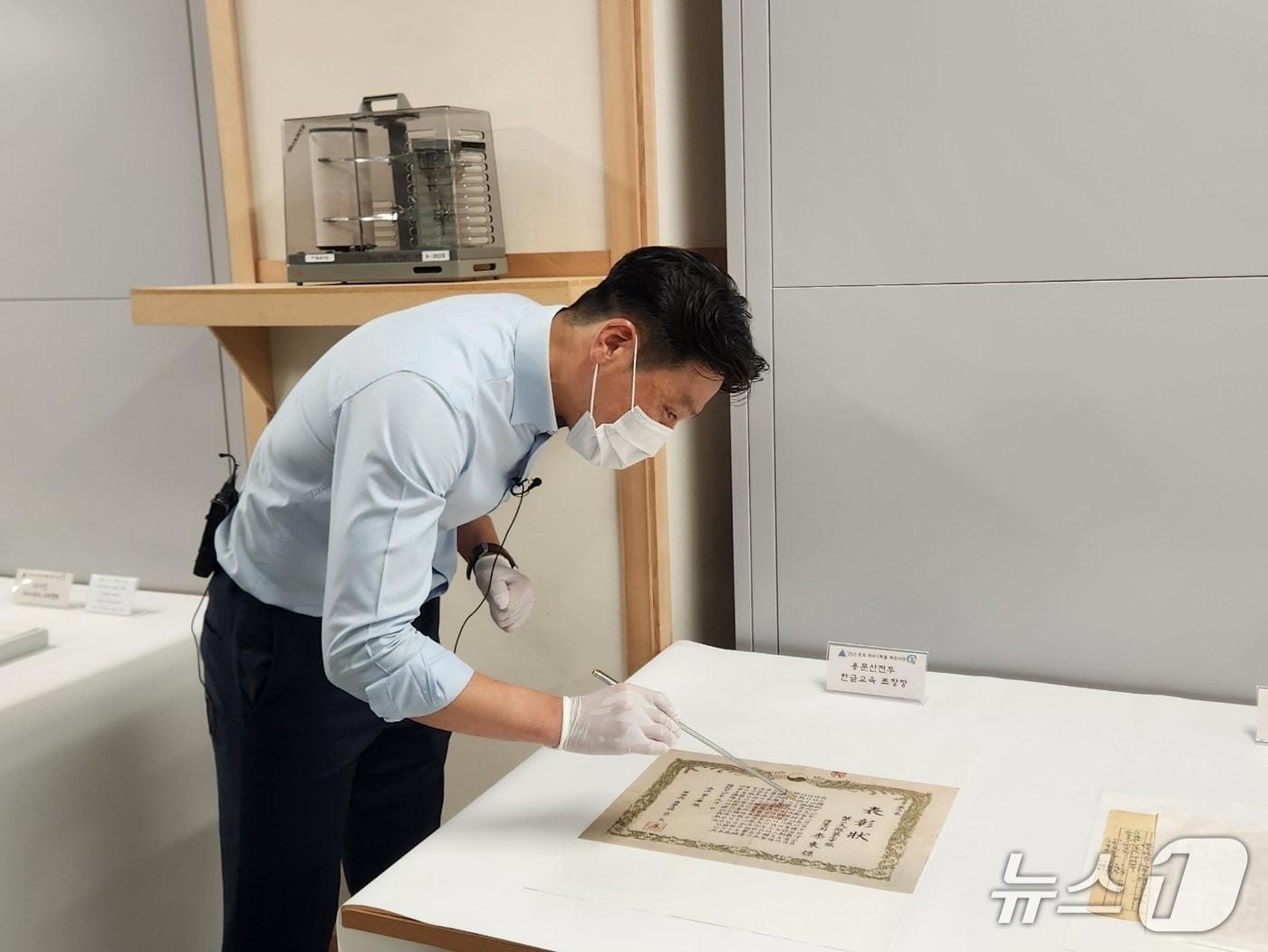 본문 이미지 - 충남 계룡대의 육군기록정보관리단 관계자가 용문산 전투 중 수여된 문맹 장병 한글 교육 관련 표창장에 대해 설명하고 있다. 2025.06.23 ⓒ 뉴스1 김예원 기자