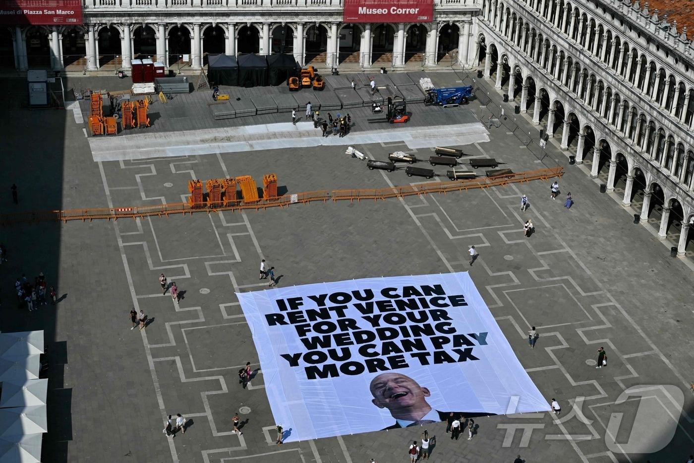 23일&#40;현지시간&#41; 국제 환경단체 그린피스 활동가들이 이탈리아 베네치아의 산 마르코 광장에서 제프 베이조스의 사진과 함께 &#34;당신이 결혼식 장소로 베네치아를 빌릴 수 있다면 더 많은 세금을 내야 한다&#34;는 문구가 적힌 대형 현수막을 설치하고 있다. 베네치아에서는는 이달 말 아마존 창업자 겸 CEO 제프 베조스와 언론인 로렌 산체스의 결혼식을 열릴 예정이며, 200명 이상의 하객이 참석할 것으로 예상된다. 25.06.23 ⓒ AFP=뉴스1 ⓒ News1 김예슬 기자