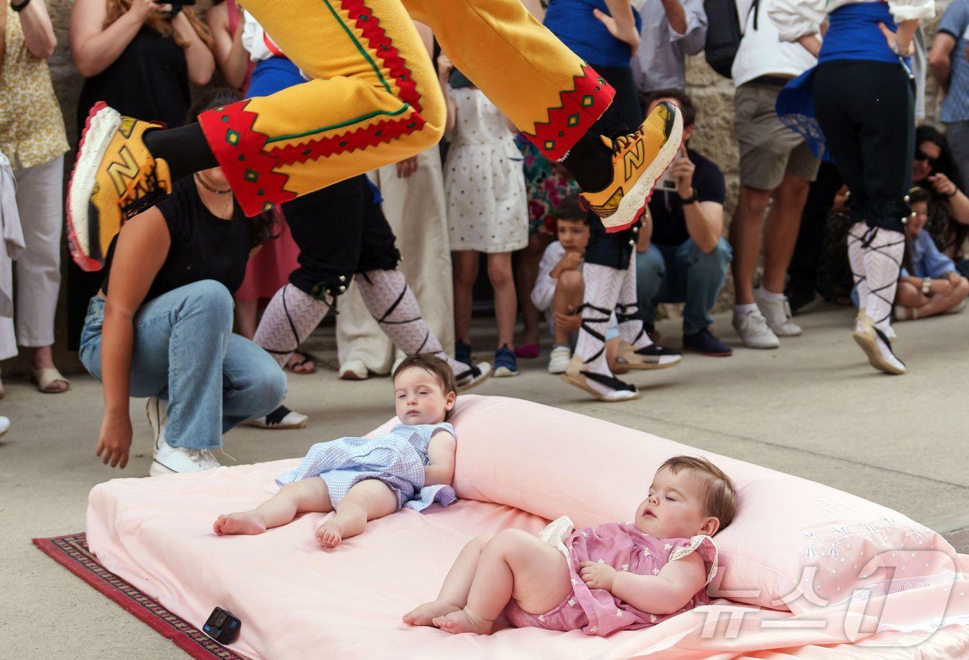 22일(현지시간) 스페인 부르고스 인근 카스트리요 드 무르시아 마을에서 열린 '엘 콜라초(El Colacho)'축제에서 악마를 상징하는 '콜라초'가 아기들을 뛰어넘고 있다. ⓒ AFP=뉴스1