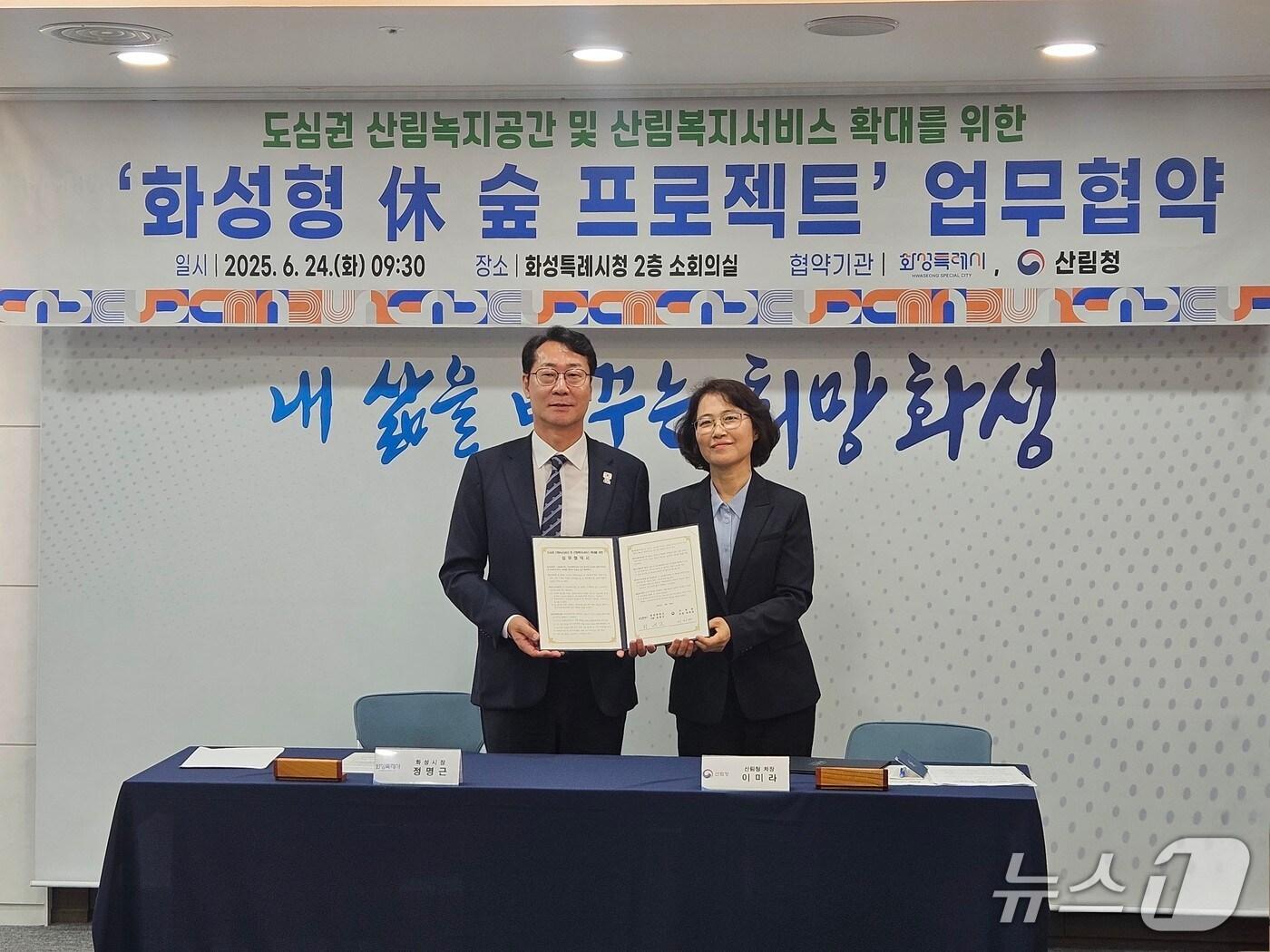 본문 이미지 - 이미라 산림청 차장(오른쪽)과 정명근 화성특례시장이 도심권 산림녹지공간 및 산림복지서비스 확대를 위한 업무협약을 체결하고 기념촬영을 하고 있다.(산림청 제공.재판매 및 DB금지)/뉴스1 