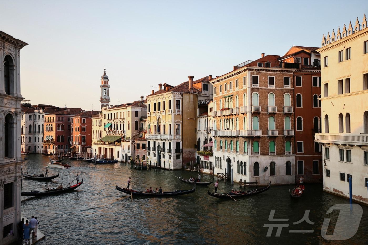 본문 이미지 - 이탈리아 베네치아의 아름다운 건물과 운하를 지나는 곤돌라들이 평화롭다. 하지만 베네치아에서는 오는 26~28일 제프 베이조스 아마존 창업자의 결혼식이 예정되어 시민단체와 환경단체의 비난을 사고 있다. 2025.06.22. ⓒ 로이터=뉴스1