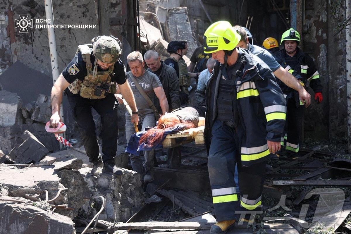 본문 이미지 - 24일&#40;현지시간&#41; 러시아의 미사일 공격을 받은 우크라이나 드니프로페트로우스크에서 구조대가 부상을 입은 여성을 구출하고 있다. 사진은 우크라이나 국가비상사태청 제공. 2025.06.24 ⓒ 로이터=뉴스1 ⓒ News1 김지완 기자