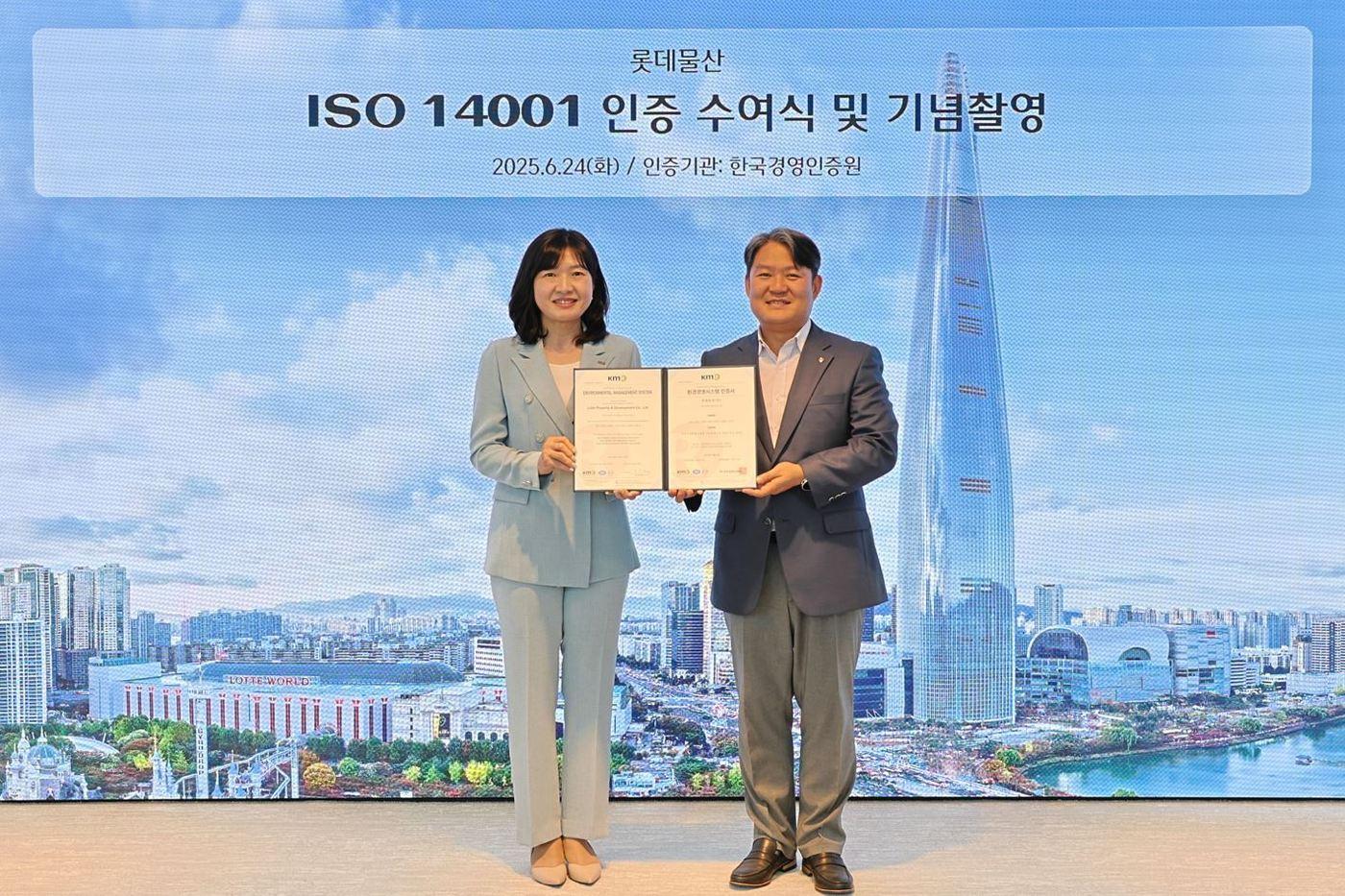 환경경영시스템&#40;ISO 14001&#41; 인증 수여식에 참석한 황은주 한국경영인증원 대표이사와 경민호 롯데물산 기술안전부문장&#40;왼쪽부터&#41;이 기념촬영을 하고 있다&#40;롯데물산 제공&#41;.