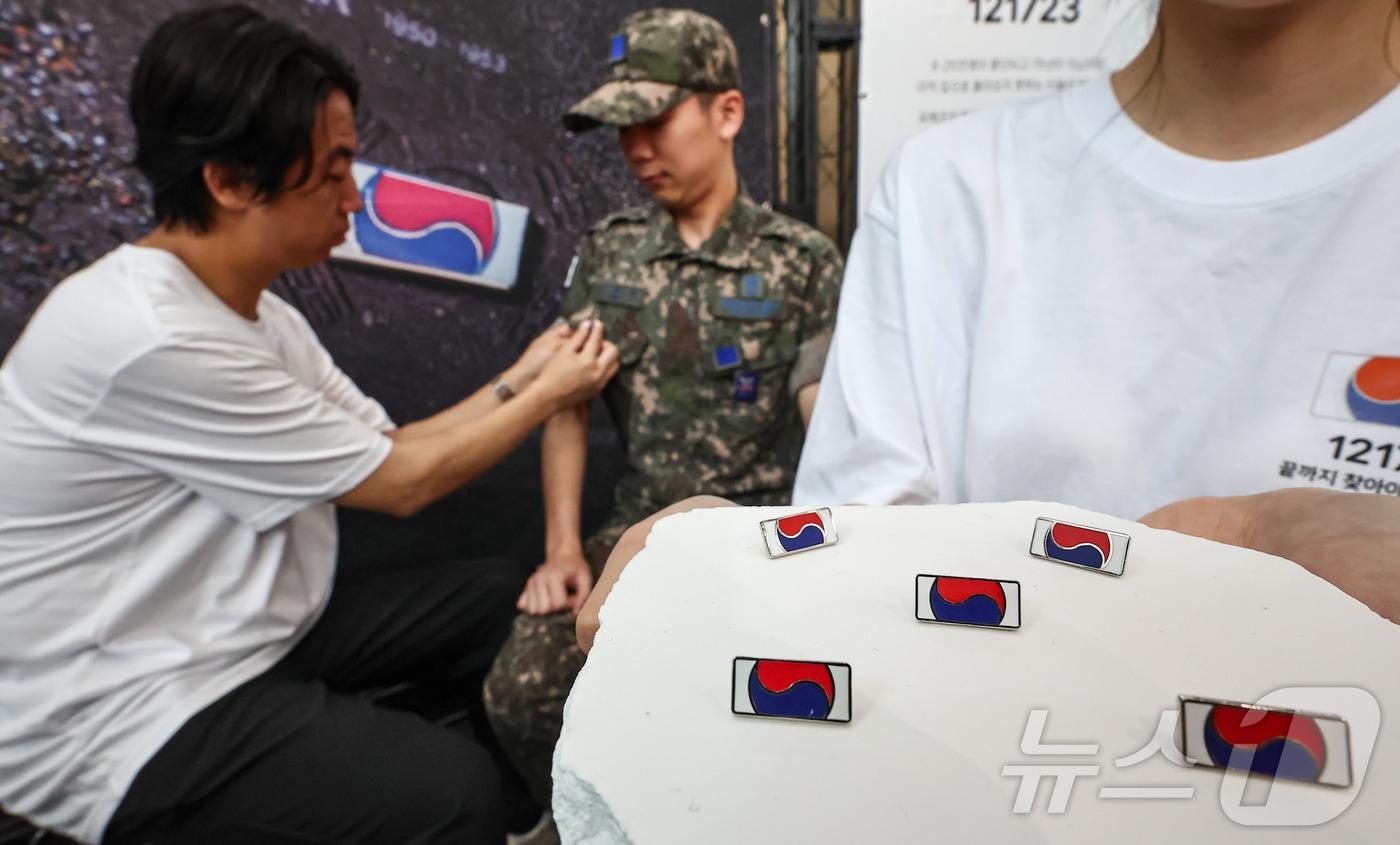25일 서울 중구 서울역 대합실에 마련된 '태극기 부스'에서 군인들이 태극기 배지를 패용하고 있다.  2025.6.25/뉴스1 ⓒ News1 김도우 기자