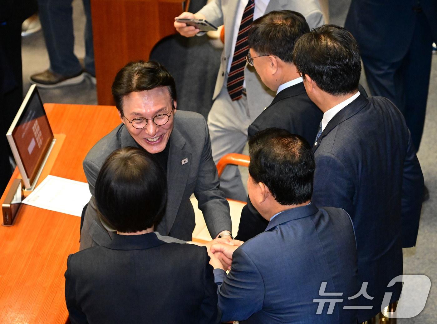 본문 이미지 - 김민석 국무총리 후보자가 26일 국회에서 열린 제426회국회&#40;임시회&#41; 제2차 본회의에서 더불어민주당 의원들과 인사를 나누고 있다./뉴스1 ⓒ News1 국회사진기자단