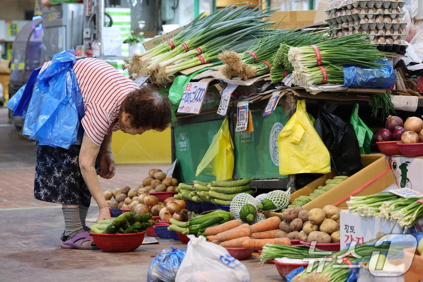 이재명 대통령이 국회에서 제2차 추가경정예산&#40;추경&#41;안 시정연설을 한 26일 서울의 한 전통시장에서 한 상인이 비닐봉투를 허리에 두른 채 장사 준비를 하고 있다. 이 대통령은 이날 약 13조 원 규모의 민생회복 소비쿠폰 예산에 관해 &#34;모든 국민은 1인당 15만 원을 받되 형편과 지역에 따라 최대 52만 원까지 지원하게 된다＂고 말했다. 2025.6.26/뉴스1 ⓒ News1 신웅수 기자