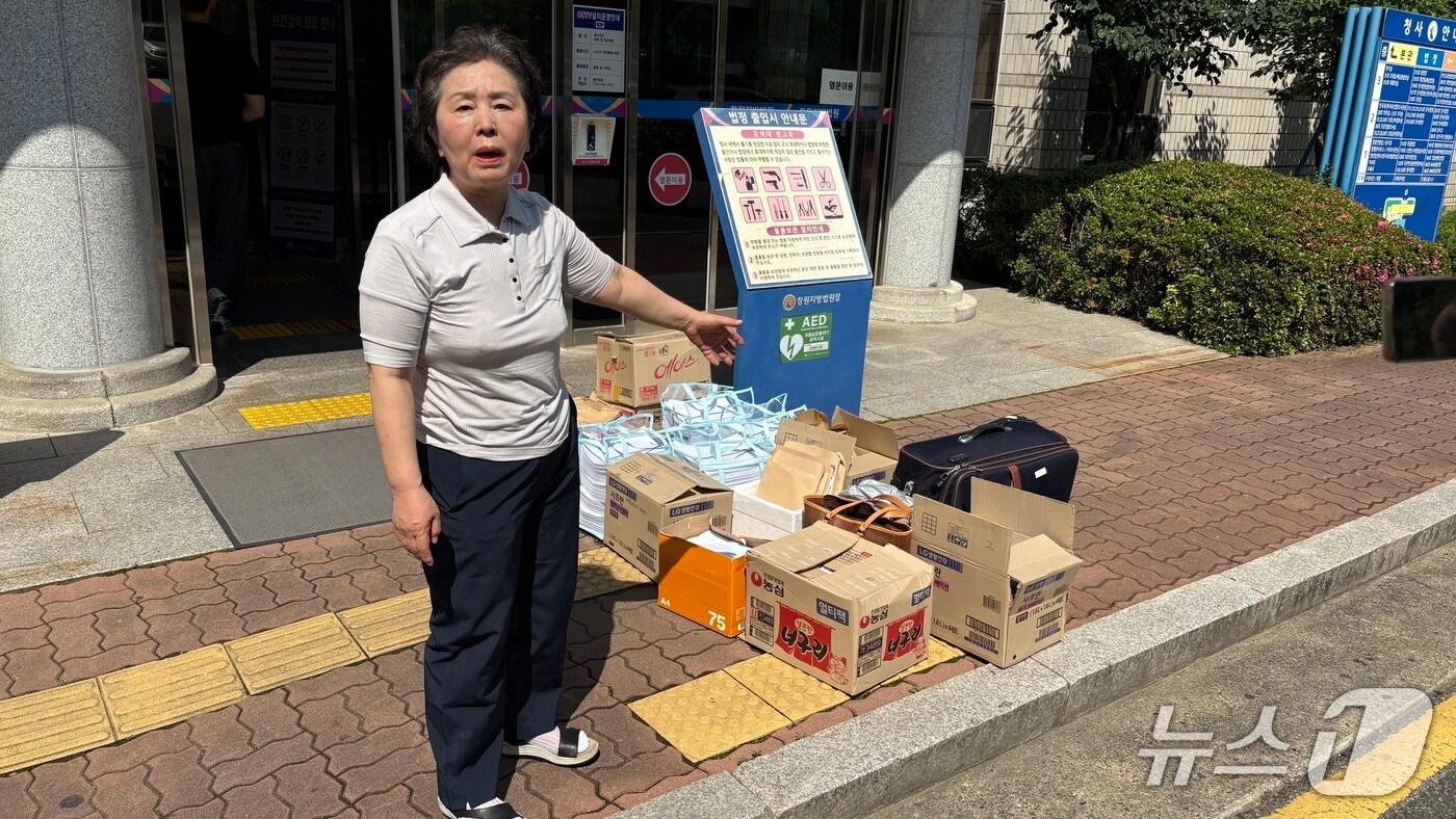 김영선 전 국회의원이 26일 추가 기소된 정치자금법 위반 혐의 사건 3차 공판에 출석하기 전 창원지법 법정동 앞에서 사건 관련 서류를 취재진에게 보여주고 있다. 2025.6.26/뉴스1 강정태 기자