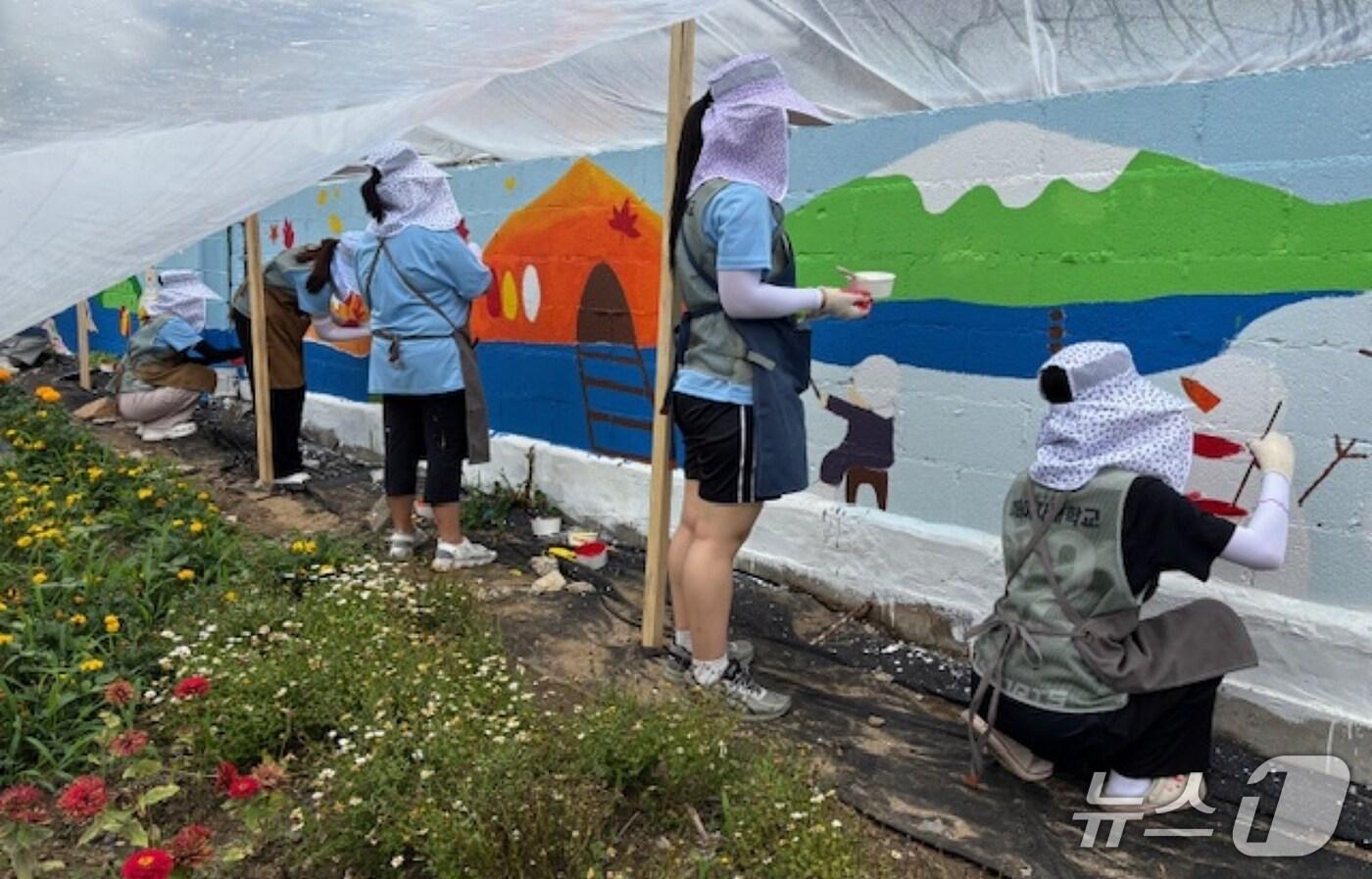 이화여자대학교 배꽃나눔실천단 소속 학생들이 충북 괴산에서 벽화 그리기 재능기부 봉사활동을 하고 있다.(괴산군 제공, 재판매 및DB금지)/뉴스1