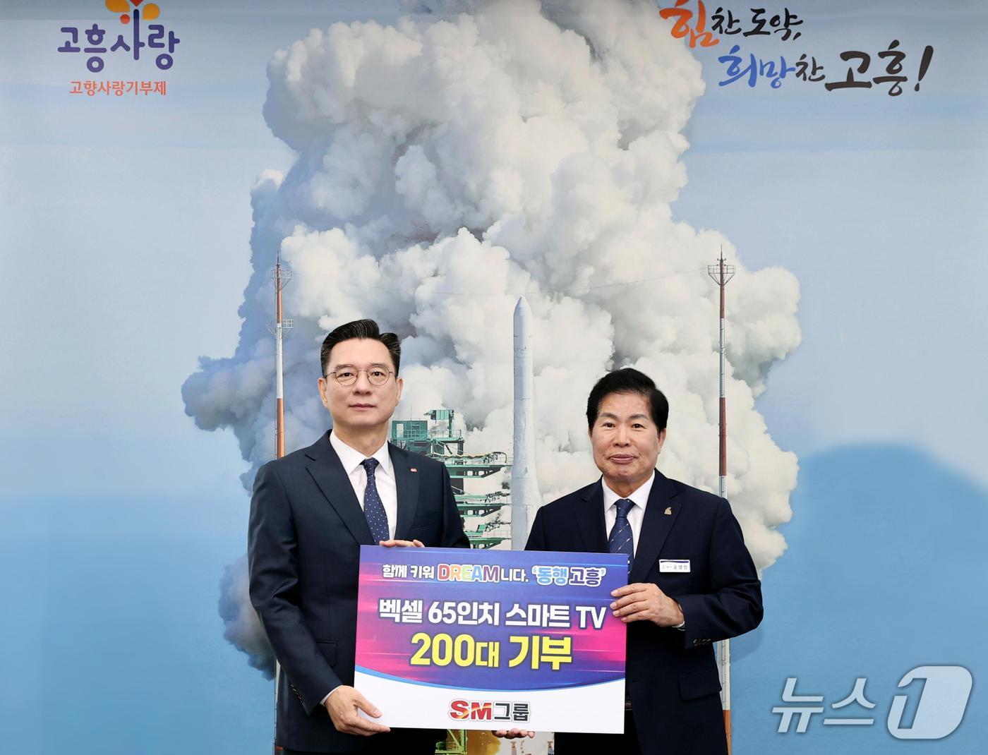 본문 이미지 - SM벡셀 배터리사업부문 최세환 대표이사&#40;왼쪽&#41;와 공영민 전남 고흥군수가 지난 4월 28일 고흥군청에서 열린 출산가정 스마트TV 기부식에 참석해 기념촬영을 하고 있다. &#40;SM그룹 제공&#41;