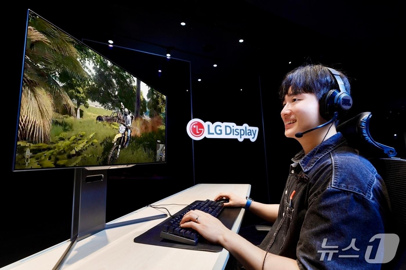 LG디스플레이 모델이 4세대 기술이 적용된 27인치 OLED 모니터 패널로 게임을 즐기고 있다.(LG디스플레이 제공)