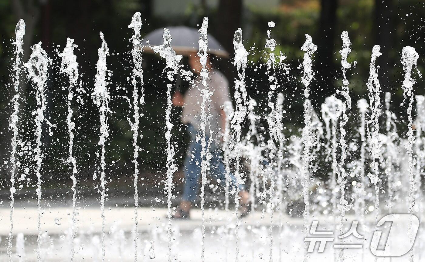 대구·경북에 올여름 첫 폭염주의보가 발효된 27일 오후 대구 서구 평리공원에서 양산을 쓴 시민이 바닥분수 옆을 지나고 있다. 2025.6.27/뉴스1 ⓒ News1 공정식 기자