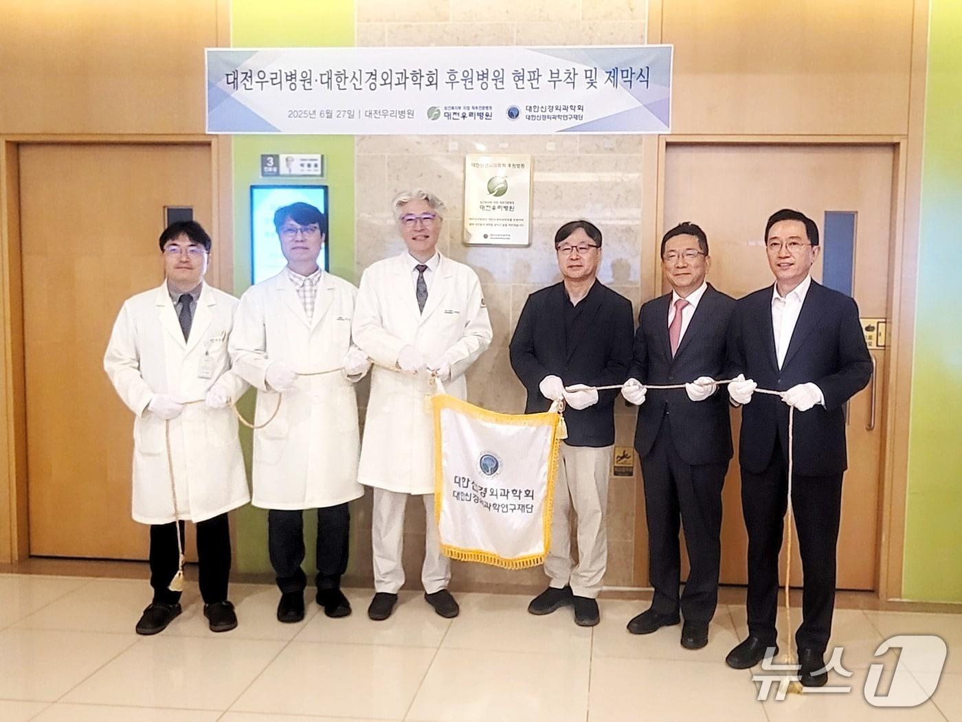 본문 이미지 - 대전우리병원과 대한신경외과학회 관계자들이 27일 후원병원 지정 기념 현판식을 갖고 기념사진을 촬영하고 있다.(우리병원 제공) /뉴스1