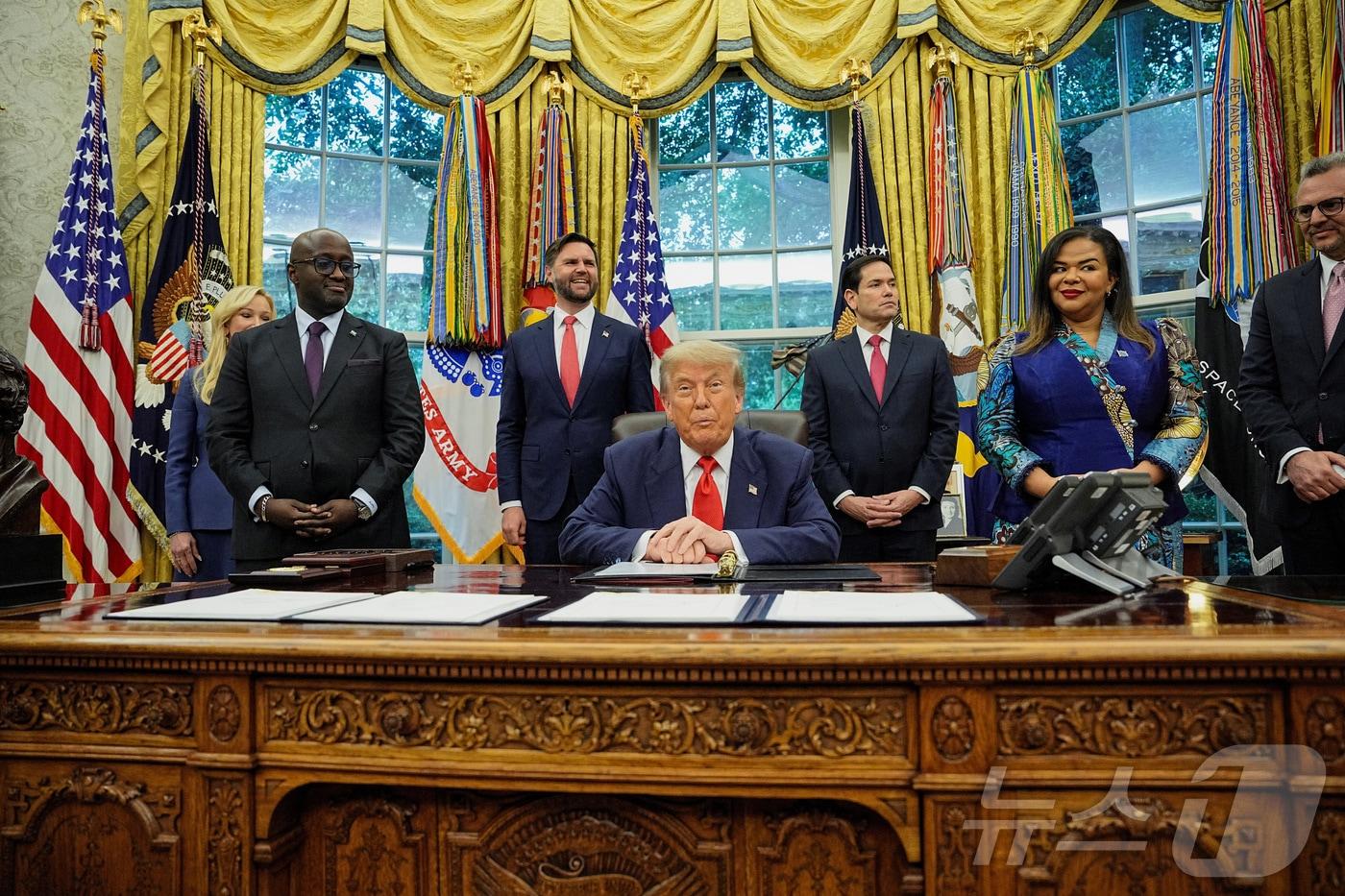 도널드 트럼프 미국 대통령이 27일&#40;현지시간&#41; 백악관 집무실에서 테레즈 카이쾀바 와그너 콩고 외무장관과 올리비에 은두훈기레헤 르완다 외무장관과 함께 평화협정 체결 기념 촬영을 하고 있다. 2025.6.27 ⓒ 로이터=뉴스1 ⓒ News1 강민경 기자