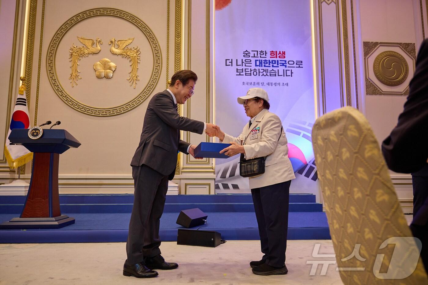 이재명 대통령이 지난 27일 청와대 영빈관에서 열린 '호국보훈의 달, 대통령의 초대' 행사에서 특별 초청대상자인 이춘자 씨에게 선물을 전달하고 있다. (이재명 대통령 SNS. 재판매 및 DB 금지) 2025.6.28/뉴스1 ⓒ News1 이재명 기자