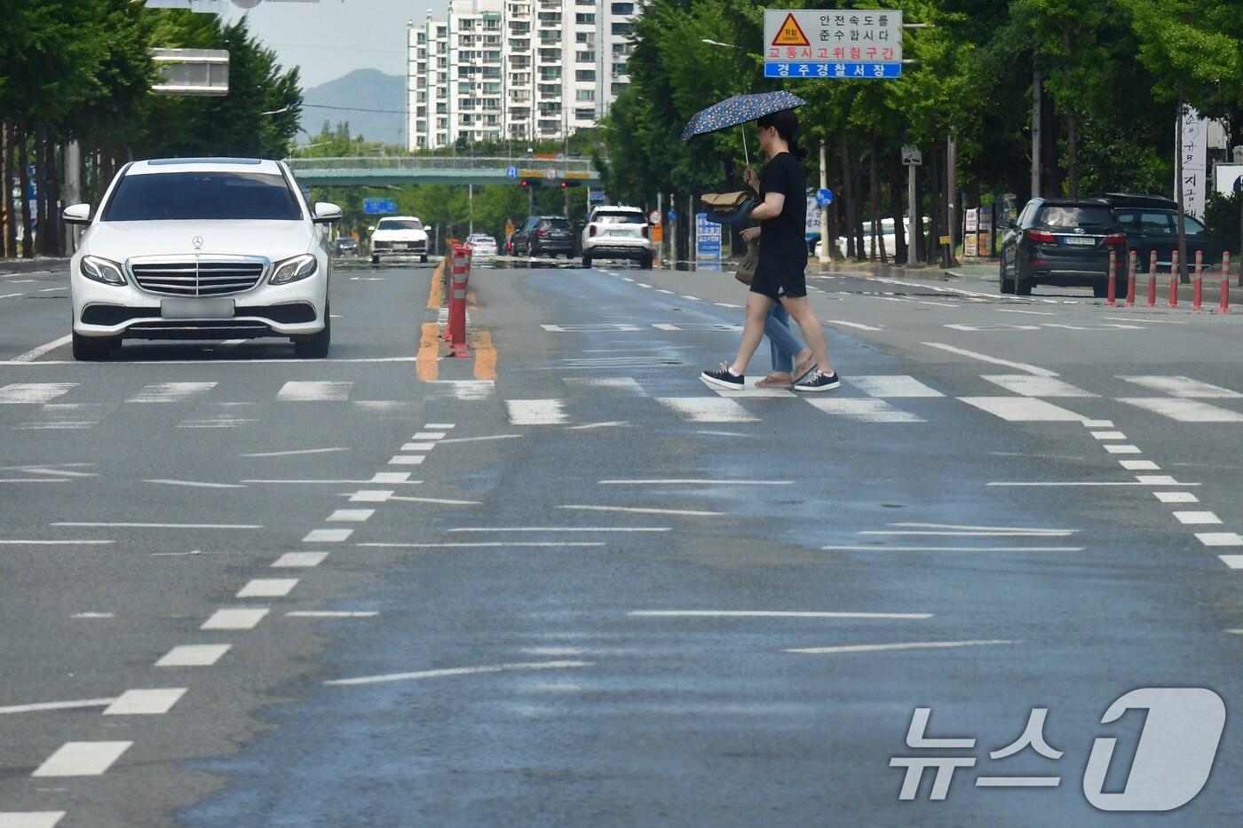 경북 경주시 전역에 폭염경보가 발령된 29일 오후 용강동 교차로에서 양산을 쓴 시민이 횡단보도를 건너가고 있다. 이날 경주 지역 낮 최고 기온은 37.2도까지 치솟았다. 2025.6.29/뉴스1 ⓒ News1 최창호 기자