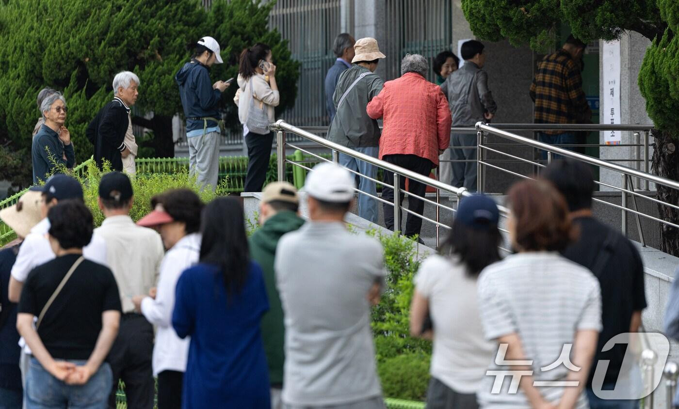 제21대 대통령 선거일인 3일 서울 영등포구 여의도 윤중중학교에 마련된 투표소를 찾은 시민들이 길게 줄 서 있다. 2025.6.3/뉴스1 ⓒ News1 이승배 기자