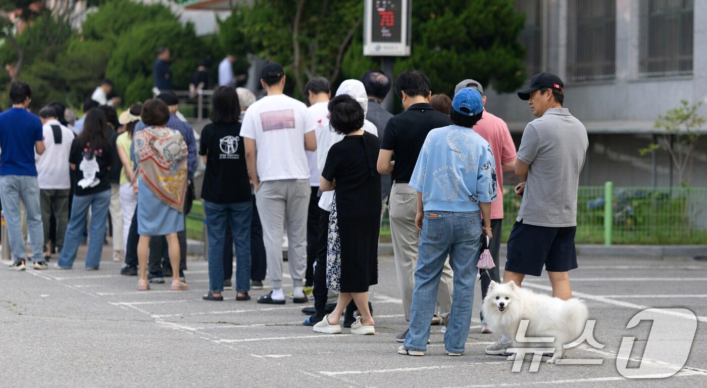 제21대 대통령 선거일인 3일 서울 영등포구 여의도 윤중중학교에 마련된 투표소를 찾은 시민들이 투표를 위해 줄 서 있다. 2025.6.3/뉴스1 ⓒ News1 이승배 기자