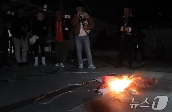 본문 이미지 - 지난 3월 11일 충북대 교내 에서 유튜버 등 청년들이 탄핵찬성 현수막을 불태우는 모습. / 뉴스1 ⓒ News1 뉴스1 박건영 기자