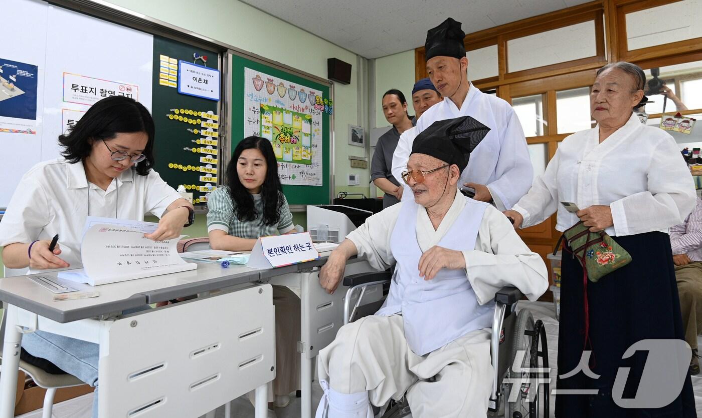 본문 이미지 - 제21대 대통령 선거일인 3일 오전 충남 논산 연산초등학교에 마련된 연산 제1투표소에서 양지서당 유복엽 큰 훈장이 가족과 함께 투표용지를 받기 위해 기다리고 있다. 2025.6.3/뉴스1 ⓒ News1 김기태 기자