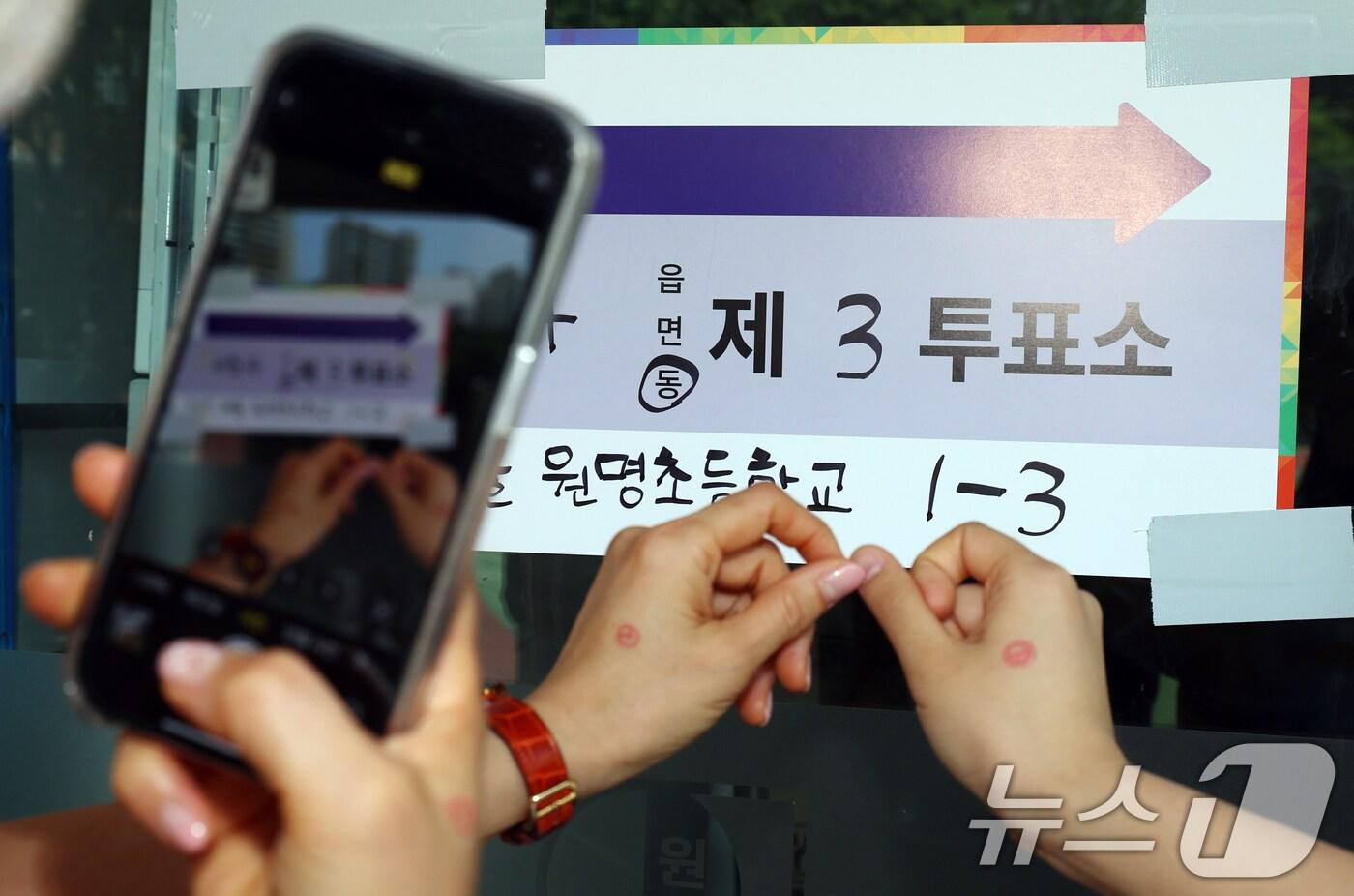 제 21대 대통령 선거일인 3일 오전 서울 서초구 원명초등학교에 마련된 서초4동 제3투표소에서 시민들이 투표를 마치고 인증샷을 촬영하고 있다. 2025.6.3/뉴스1 ⓒ News1 김명섭 기자