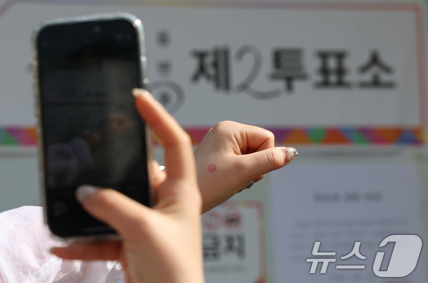 제21대 대통령 선거일인 3일 경기 수원시 권선구 여기산게이트볼장에 마련된 서둔동제2투표소에서 한 유권자가 투표를 마치고 인증샷을 남기고 있다. ⓒ News1 김영운 기자