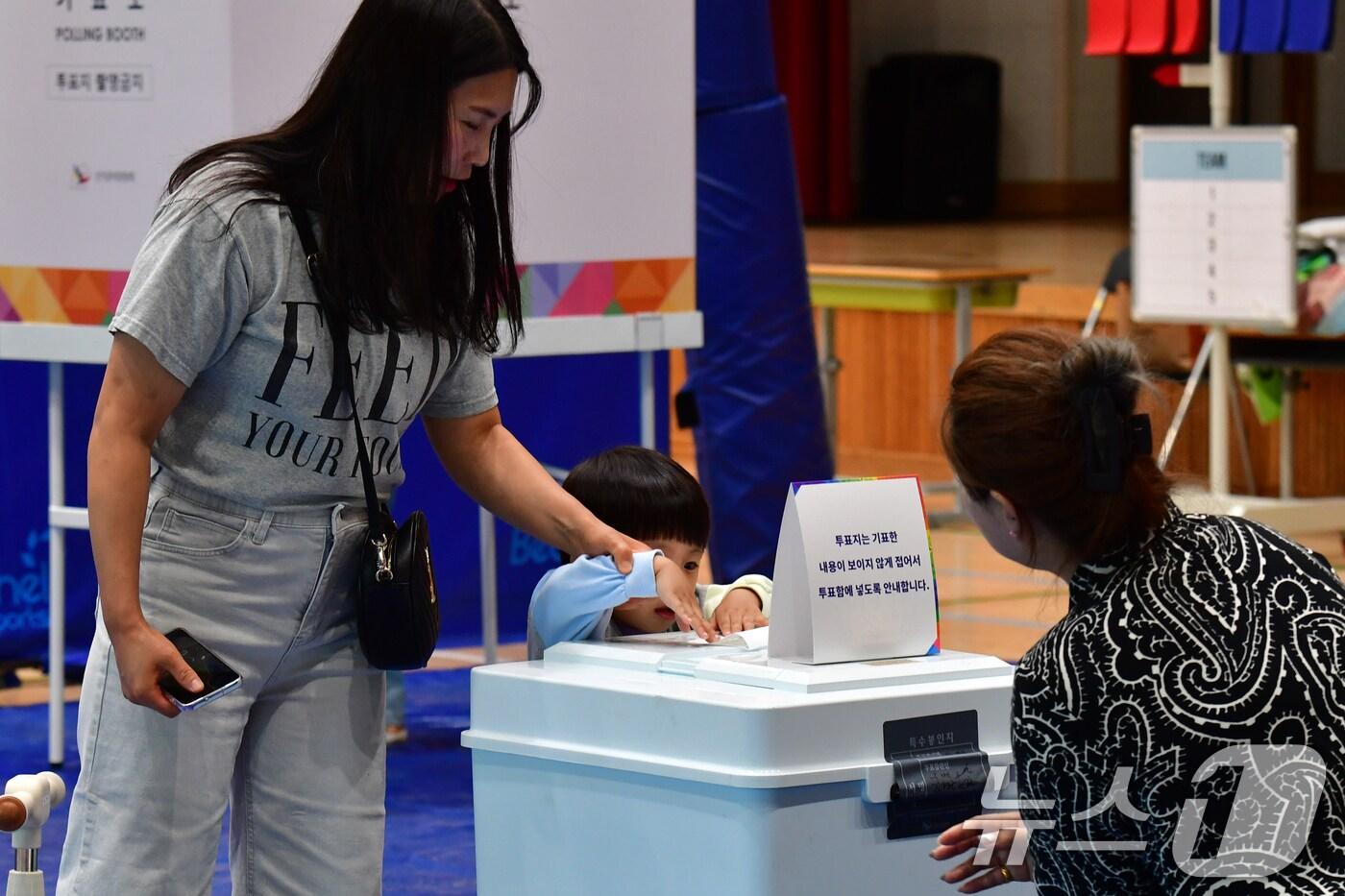 제21대 대통령 선거일인 3일 경북 포항시 남구 오천읍 문덕초등학교에 마련된 투표소에서 어린이가 엄마의 투표용지를 기표함에 넣고 있다. 2025.6.3/뉴스1 ⓒ News1 최창호 기자