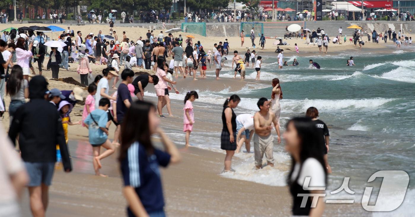 제21대 대통령 선거일이자 초여름 날씨를 보인 3일 오후 부산 해운대해수욕장을 찾은 시민, 관광객 등이 물놀이를 즐기며 더위를 식히고 있다. 2025.6.3/뉴스1 ⓒ News1 윤일지 기자