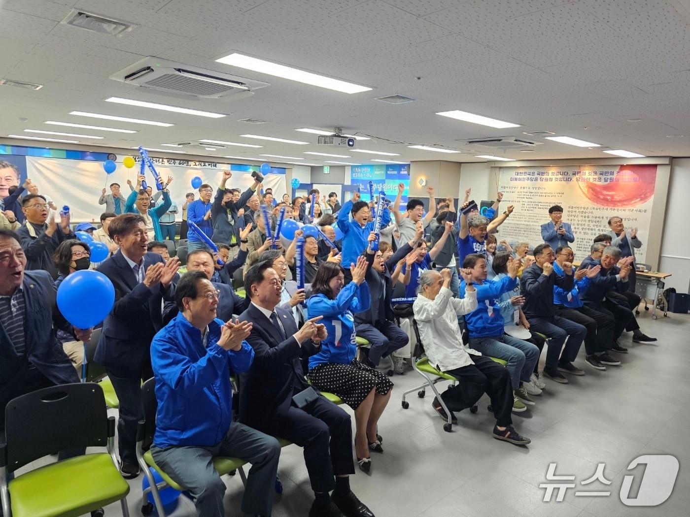 본문 이미지 - 송순호 더불어민주당 경남도당 위원장을 비롯한 도당 관계자들이 3일 오후 창원시 의창구 더불어민주당 경남도당에 마련된 제21대 대통령선거 개표상황실에서 출구조사 결과가 나오자 환호하고 있다.