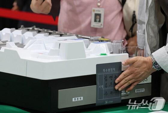 본문 이미지 -  21대 대통령선거를 하루 앞둔 2일 대전 유성구 대전컨벤션센터에 마련된 개표소에서 유성구선관위 관계자들이 개표 준비 상황을 점검한 뒤 투표지 분류기에 봉인지를 부착하고 있다. 2025.6.2/뉴스1 ⓒ News1 김기태 기자