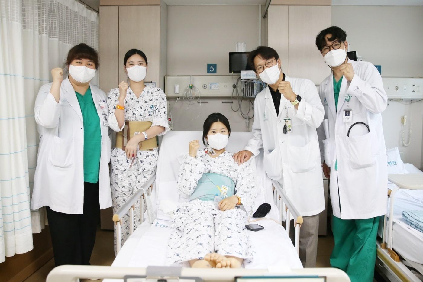 다낭성 신증후군으로 만성 신부전을 앓던 이가영 씨(가운데)가 로봇 신장이식 후 순조롭게 회복하며 지난 20일 의료진과 기념사진을 찍고 있다. 왼쪽에서 두 번째가 공여자인 언니 이 모 씨, 네 번째가 수술을 집도한 신성 서울아산병원 신·췌장이식외과 교수.(서울아산병원 제공)