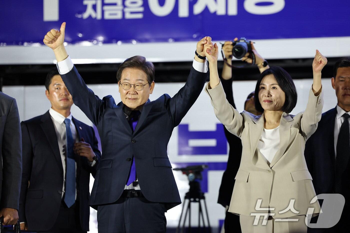 당선이 확실시 되는 이재명 더불어민주당 대선후보와 김혜경 여사가 4일 오전 서울 여의도 국회 앞에서 열린 국민 개표방송 행사에서 꽃다발을 받은 뒤 시민들을 향해 인사하고 있다. (공동취재) 2025.6.4/뉴스1 ⓒ News1 안은나 기자