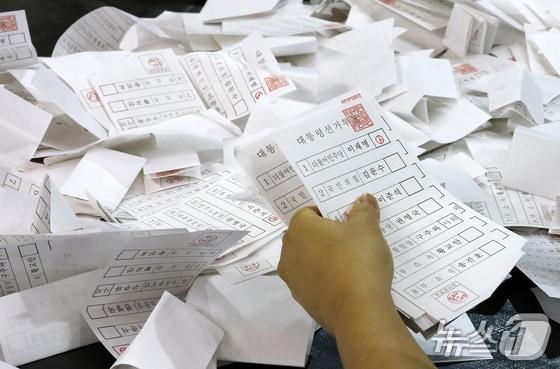 본문 이미지 -  제21대 대통령 선거 투표가 실시된 3일 대전 서구 KT인재개발원에 마련된 개표소에서 개표사무원들이 투표용지를 분류하고 있다. 2025.6.3/뉴스1 ⓒ News1 김기태 기자