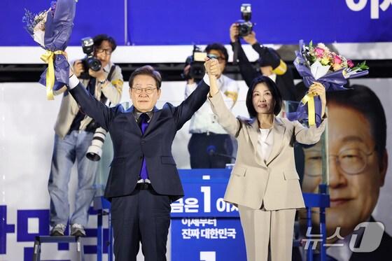 본문 이미지 -  이재명 더불어민주당 대통령 후보와 부인 김혜경 여사가 4일 오전 당선이 확실시되자 서울 여의도 국회 앞을 찾아 꽃다발을 받아 들어보이고 있다. (공동취재) 2025.6.4/뉴스1 ⓒ News1 안은나 기자