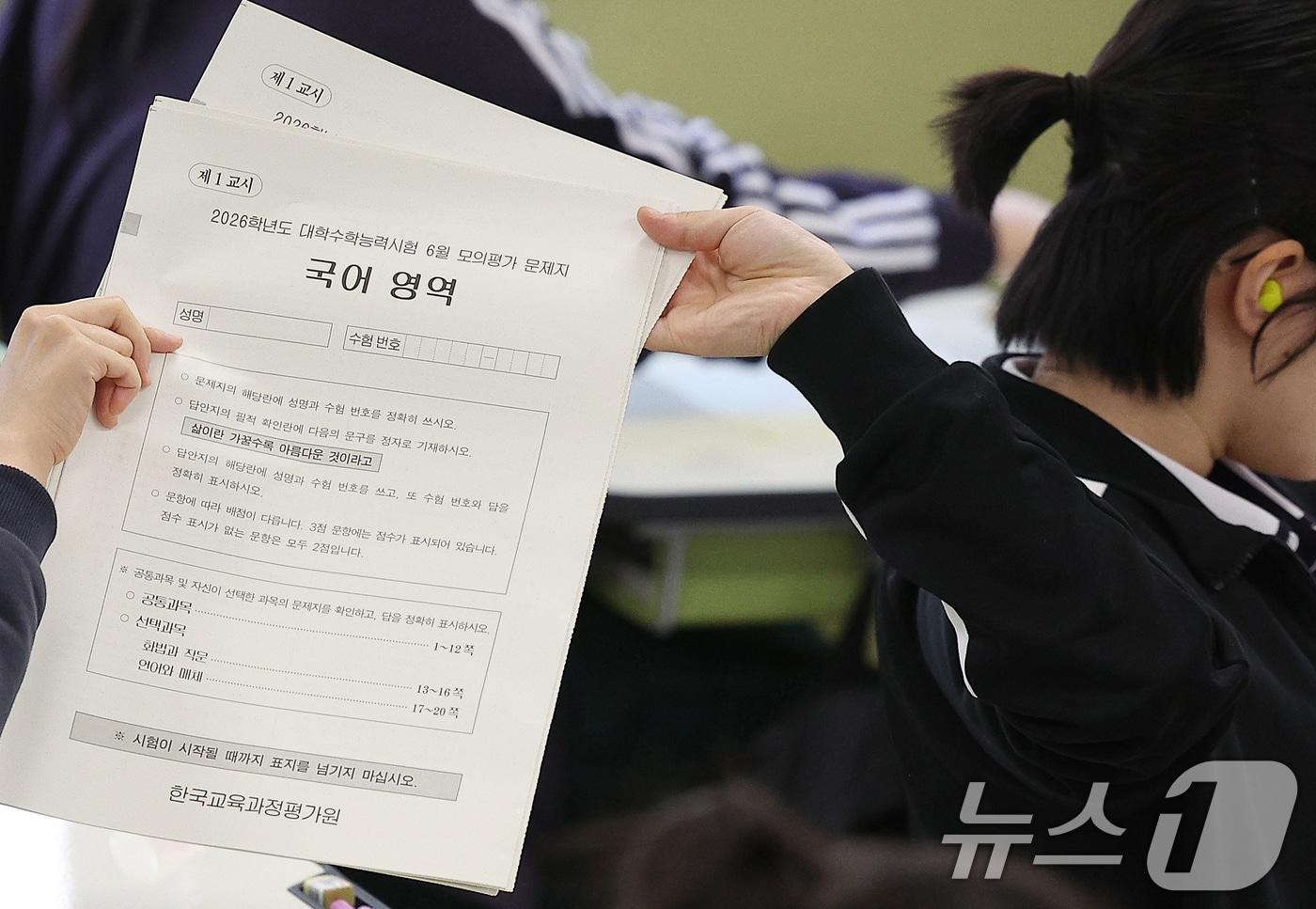 2026학년도 대학수학능력시험 6월 모의평가가 치러진 4일 오전 대구 수성구 대구여자고등학교에서 고3 학생들이 1교시 국어 영역 문제지를 뒤로 전달하고 있다. 2025.6.4/뉴스1 ⓒ News1 공정식 기자