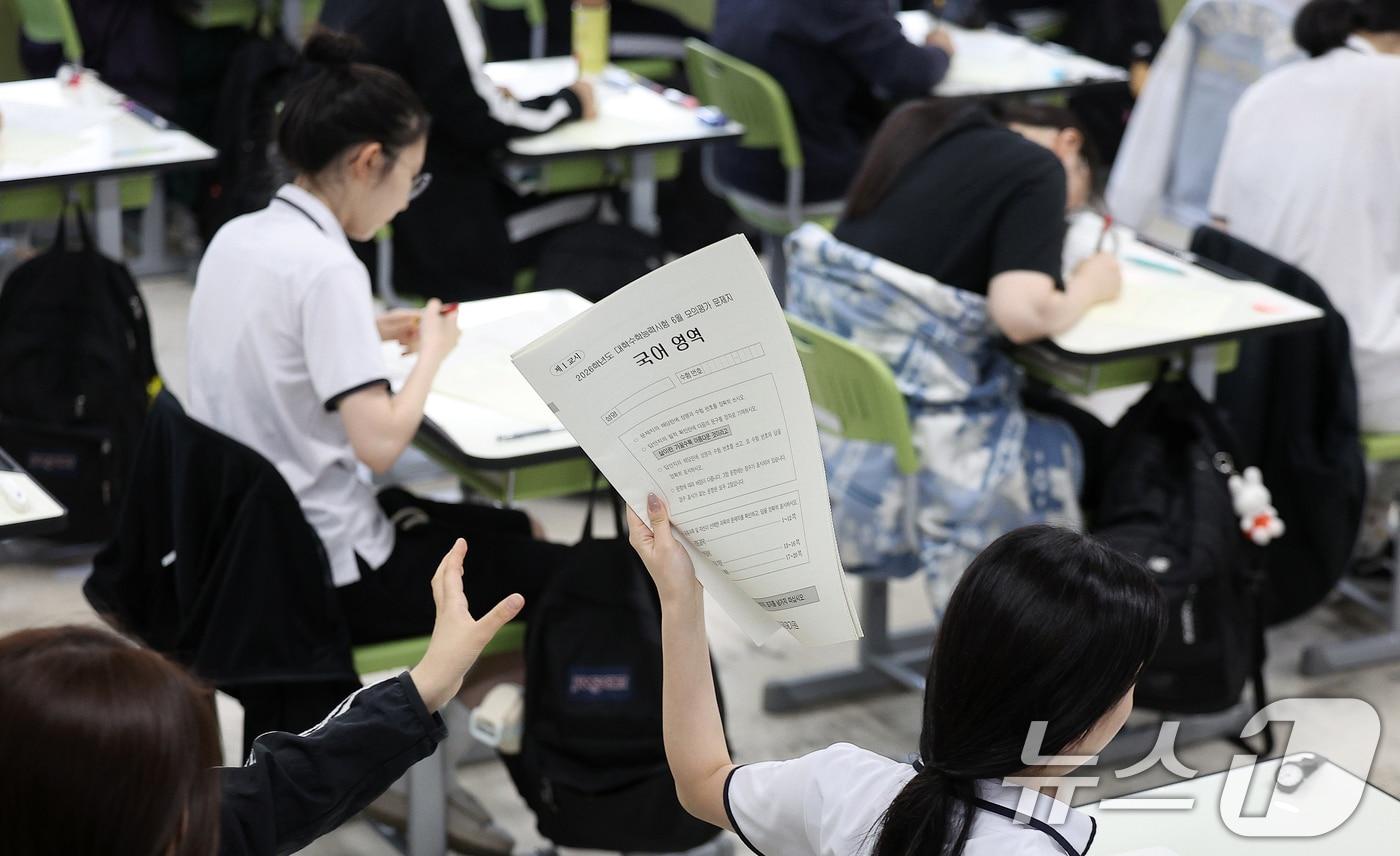 2026학년도 대학수학능력시험 6월 모의평가에 응시한 고3 학생들이 국어 영역 문제지를 뒤로 전달하고 있다. /뉴스1 ⓒ News1 공정식 기자