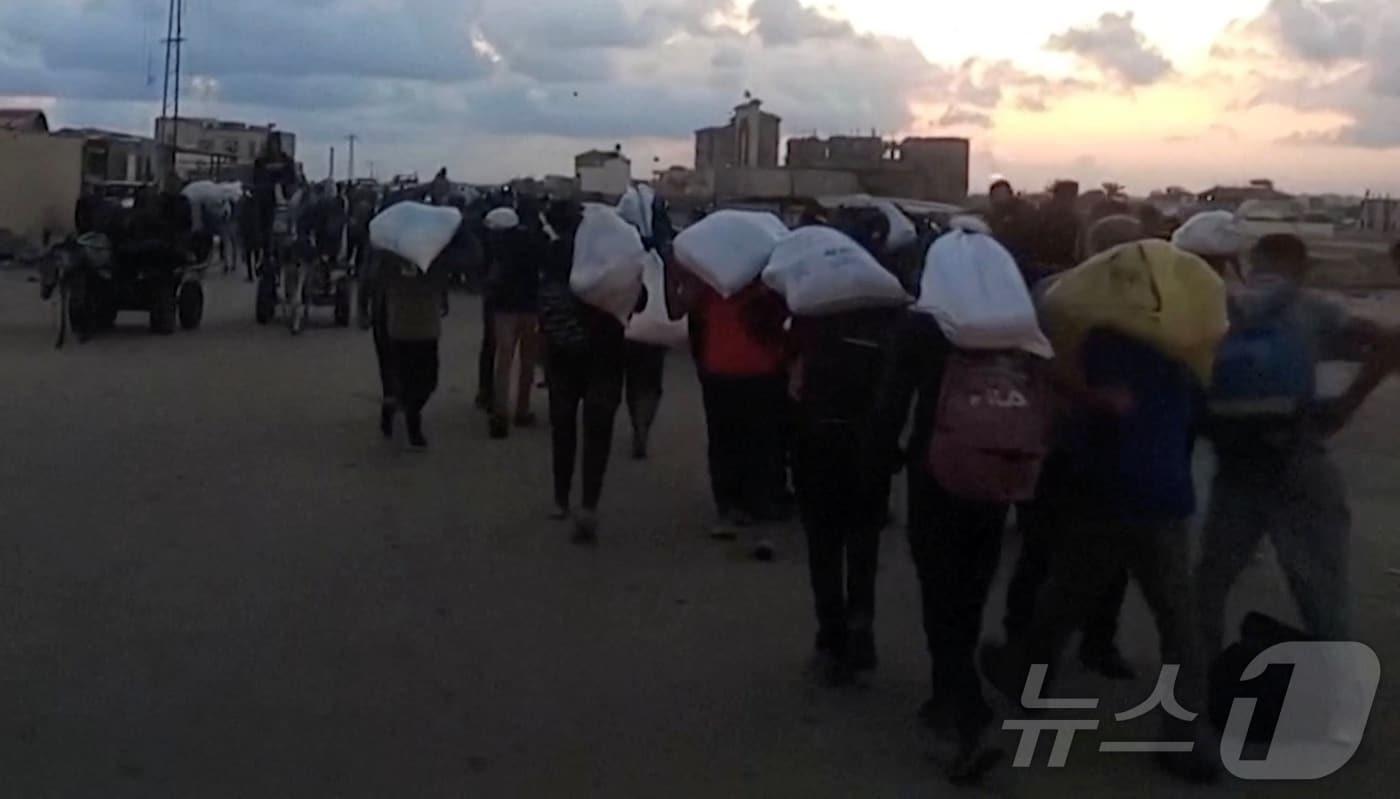 가자지구 라파에서 구호품을 배급받은 팔레스타인 주민들. 25.06.03 ⓒ 로이터=뉴스1 ⓒ News1 김예슬 기자 <자료사진>