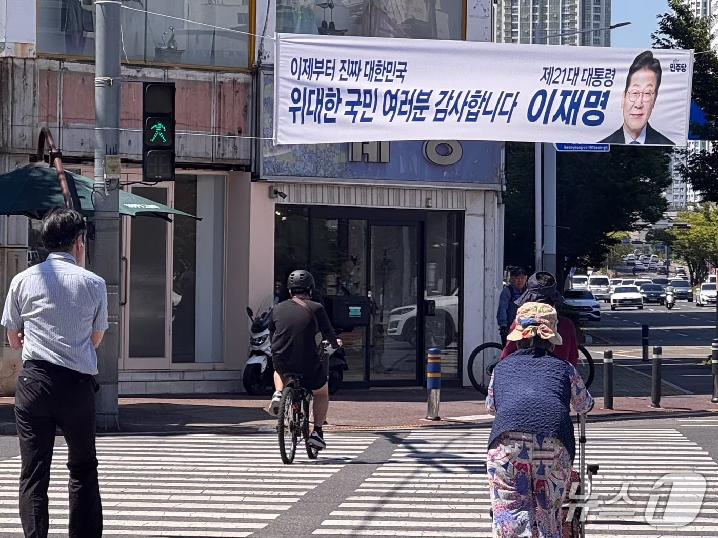 본문 이미지 - 울산 남구 삼산동에 걸린 이재명 대통령 당선 현수막 아래 시민들이 횡단보도를 건너고 있다.2025.6.4./뉴스1 김세은 기자