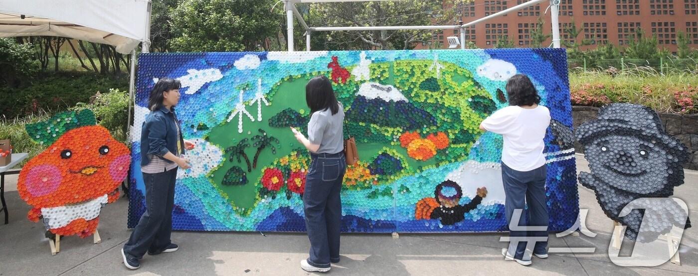 4일 오후 제주 서귀포시 제주국제컨벤션센터 야외광장에서 세계환경의 날을 맞아 열린 &#39;2025 환경 한마당 축제&#39;에서 방문객들이 폐플라스틱 뚜껑으로 만든 제주도 지도를 살펴보고 있다.2025.6.4/뉴스1 ⓒ News1 고동명 기자