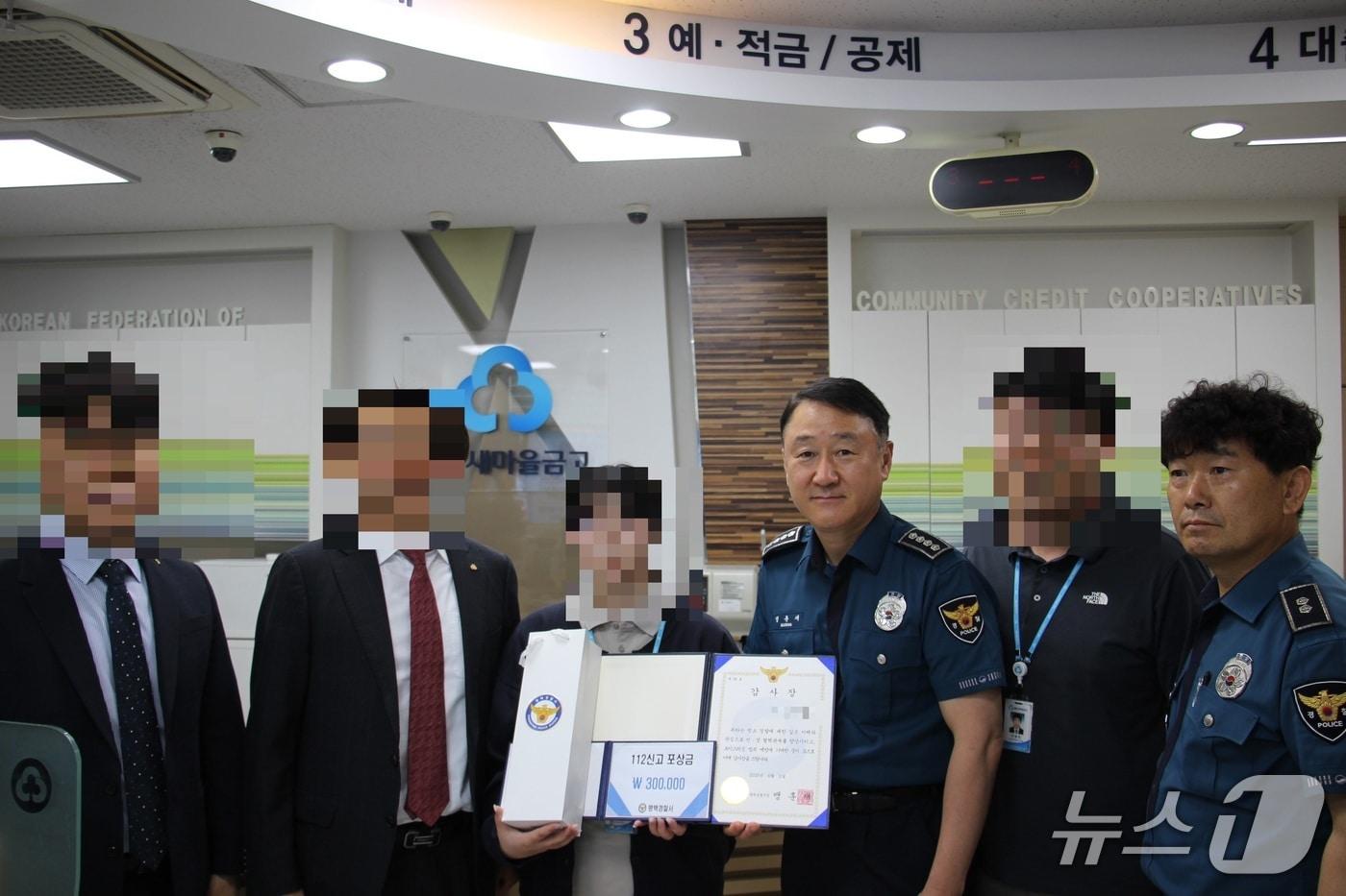 새마을금고 은행원 A씨에게 경찰서장 감사장과 112신고 포상금을 전달한 뒤 기념촬영을 하고 있다.(평택경찰서 제공)