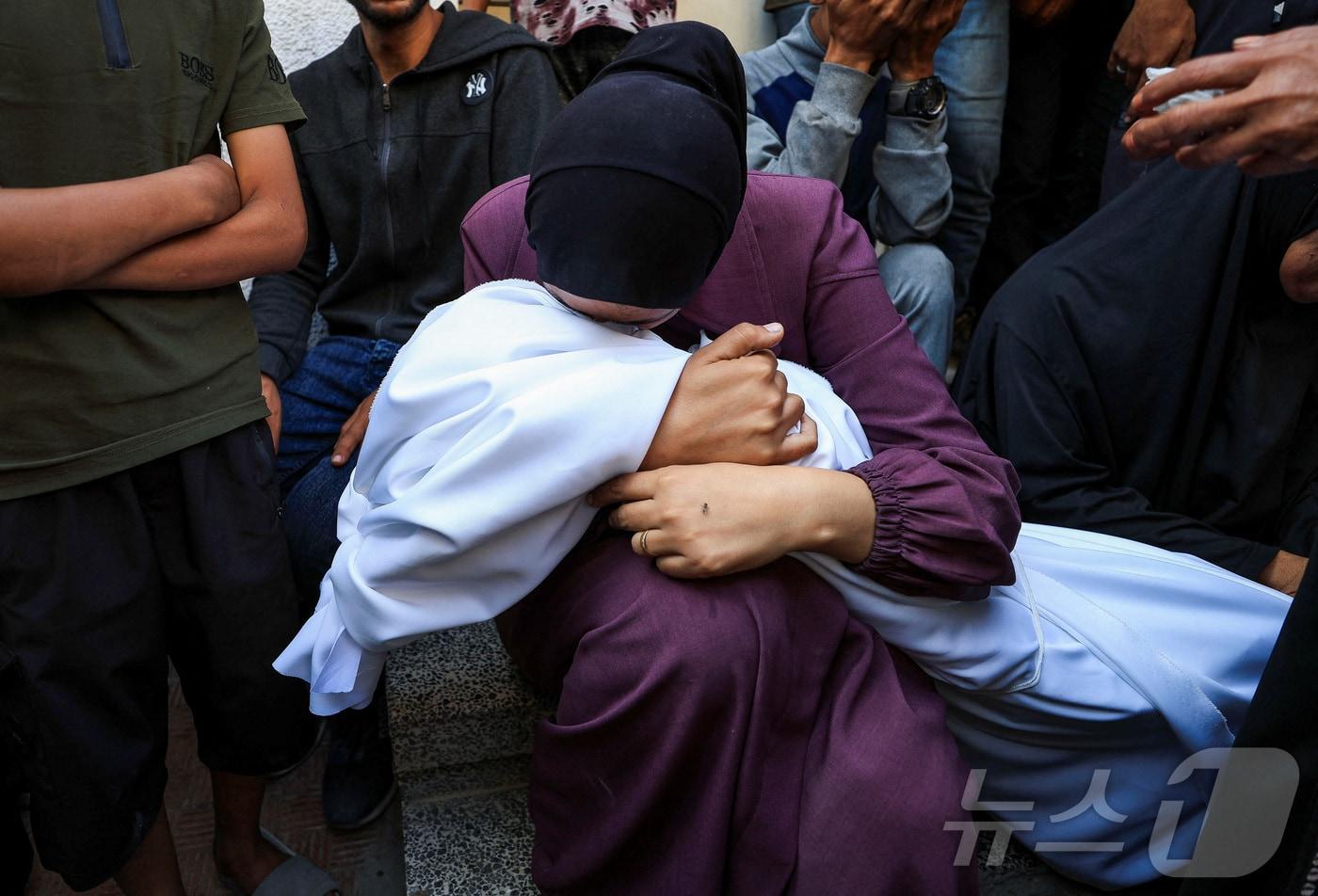 4일(현지시간) 팔레스타인 가자 시티에 있는 한 병원 장례식장에서 한 여성이 이스라엘 공격으로 숨진 이의 주검을 안고 울고 있다. 2025.06.04 ⓒ 로이터=뉴스1 ⓒ News1 최종일 선임기자