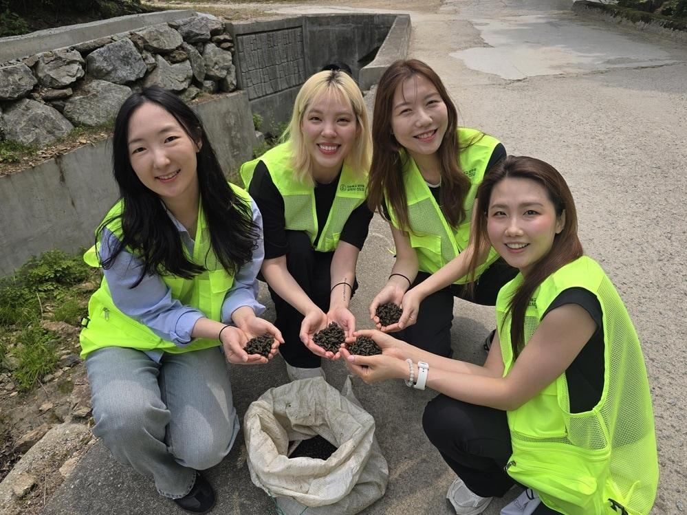 본문 이미지 - 밝은 표정으로 다슬기를 들고 포즈를 취한 참가자들. 생태 복원의 의미를 되새기며 환하게 웃고 있다. 사진=푸른환경실천협의회 제공