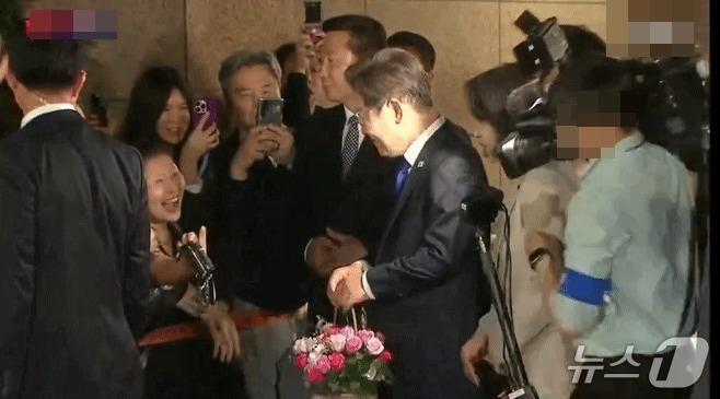 본문 이미지 -  지난 3일 밤 11시 40분 쯤 이재명 더불어민주당 대선후보가 당선이 유력시 되자 여의도 당사로 가기 위해 인천 계양구 자택을 나서면서 시민들과 인사를 하고 있다. 이 모습을 찍기 위해 MBN 카메라 기자(오른쪽)가 급히 이 후보 쪽으로 움직이는 과정에서 김혜경 여사를 밀치는 실수를 범했다. (YTN 갈무리) ⓒ 뉴스1 