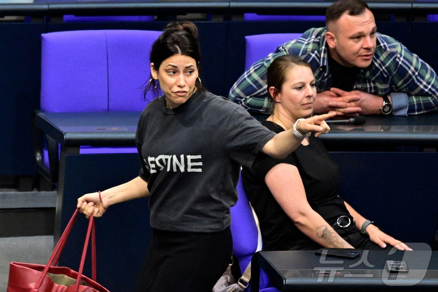 4일(현지시간) 독일 좌파당 소속의 칸진 쾨크튀르크 연방 하원의원이 '팔레스타인'이 적힌 티셔츠를 입었다는 이유로 본회의장에서 퇴장 요구를 받은 뒤 나가고 있다. 2025.06.04 ⓒ AFP=뉴스1 ⓒ News1 김지완 기자