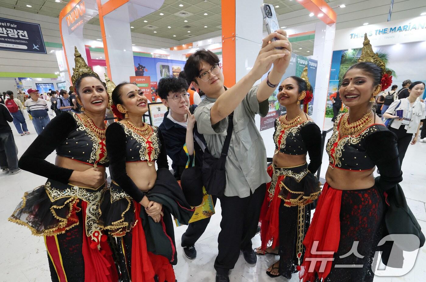 5일 서울 강남구 코엑스에서 열린 제40회 서울국제관광전을 찾은 관람객이 스리랑카 전통복장을 입은 스리랑카관광청 직원들과 기념사진을 찍고 있다. 2025.6.5/뉴스1 ⓒ News1 박세연 기자
