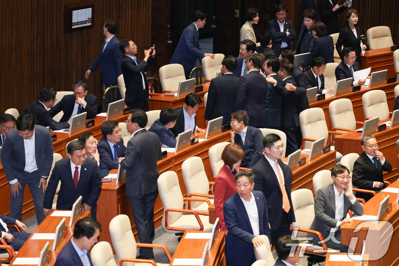 더불어민주당 의원들이 5일 오후 서울 여의도 국회 본회의장에서 기념 촬영하는 가운데 국민의힘 의원들이 입장하고 있다. 2025.6.5/뉴스1 ⓒ News1 안은나 기자