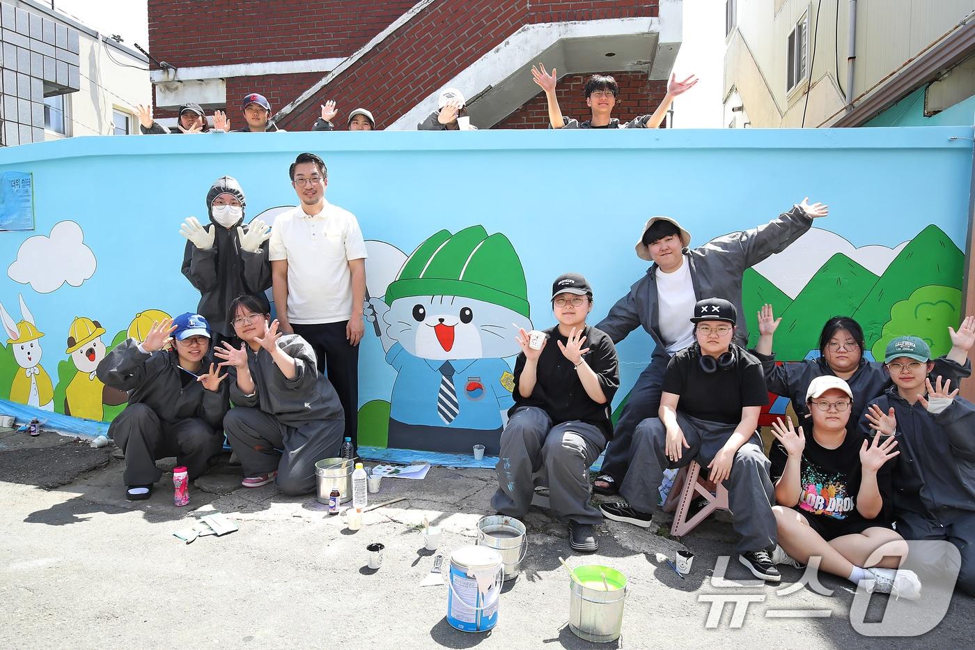 초여름 더위가 이어진 5일 오후 대구 남구 대명4동 경로당에서 페인트 작업복까지 챙겨입고 나와 '벽화 그리기'에  참여한 영남이공대 웹툰과 학생들이 기념촬영을 하고 있다. 2025.6.5/뉴스1 ⓒ News1 공정식 기자